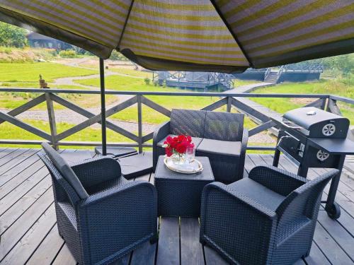 a patio with chairs and a table with a grill at Namiot glampingowy Loft in Krzesimów