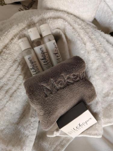 a towel with two bottles of mascara and a mensvisor at Milkwood Safari Lodge in Warmbaths