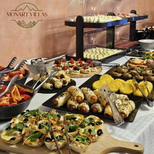 un buffet con molti tipi diversi di cibo su un tavolo di Artemis Villa a Poiana Brasov