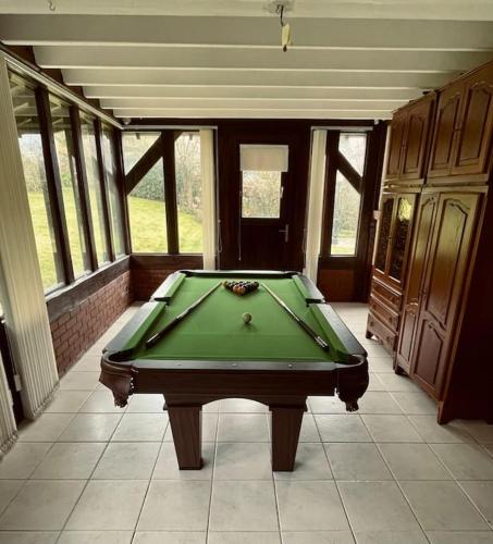 - un billard vert dans une pièce avec fenêtres dans l'établissement La groseille, à Anneville-sur-Scie