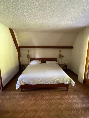 une chambre avec un lit blanc dans une pièce dans l'établissement La groseille, à Anneville-sur-Scie