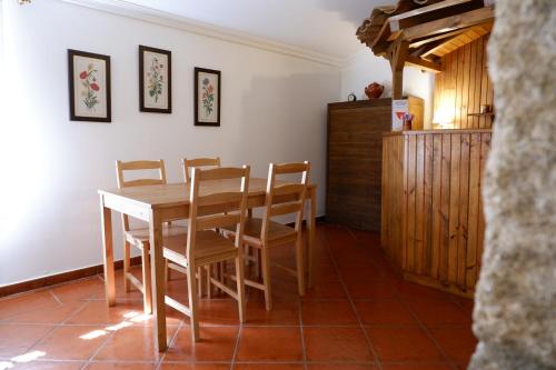 a dining room with a wooden table and chairs at Casa da Ondrinha in Capinha