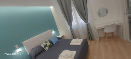 a bedroom with a blue bed with two towels at Bemy in Rome