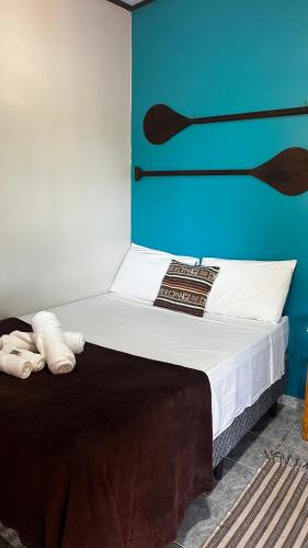 a bedroom with a bed with a blue wall at Casa da Vila - Hospedaria - 3 min do centrinho de Alter in Alter do Chao