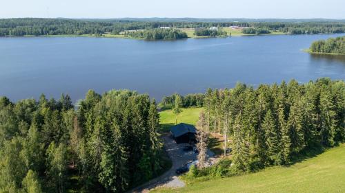 an aerial view of a lake with a cabin in the trees at Villa Rantaniitty in Tampere