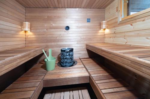a sauna with wooden paneling and a green cup at Villa Rantaniitty in Tampere