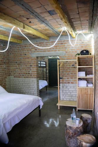 a room with a bed and a brick wall at Kazerma e Cerenit in Surrel