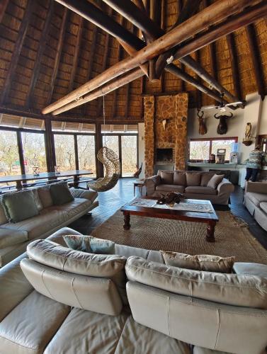 a living room with couches and a table at Milkwood Safari Lodge in Warmbaths