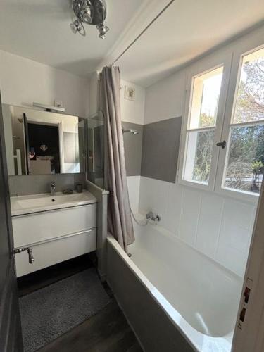 une salle de bain avec une baignoire et un lavabo dans l'établissement Les Restanques Maison de la pinède 2 chambres, à Grimaud