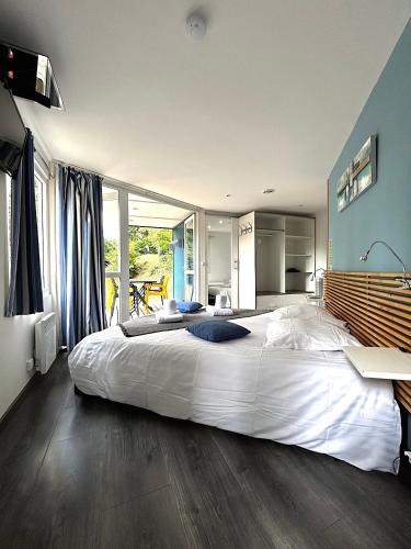 - une grande chambre avec un grand lit blanc dans l'établissement Les Chalets du Périgord, à Sarlat-la-Canéda