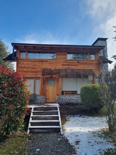 a log home with stairs leading to the front door at Encanto del Rio in Villa La Angostura