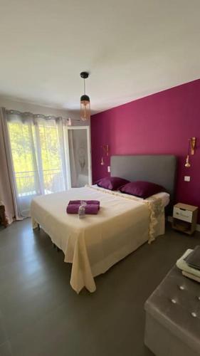une chambre avec un grand lit aux murs violets dans l'établissement Le Mas de Fabregas Villa proche des plages, à La Seyne-sur-Mer
