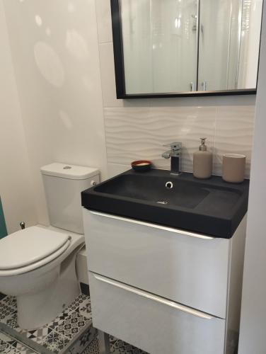 une salle de bain avec des toilettes blanches et un lavabo dans l'établissement La Cité du 56, à Dijon