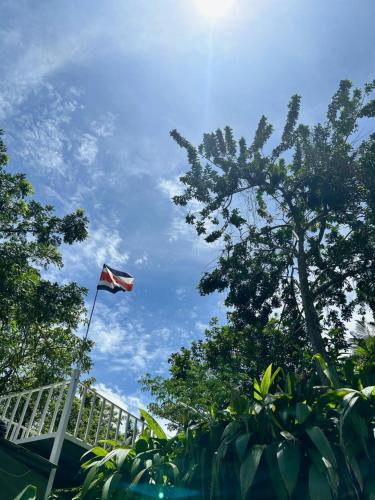 a flag flying in the sky next to some trees at B&B Garden Grecia in Grecia