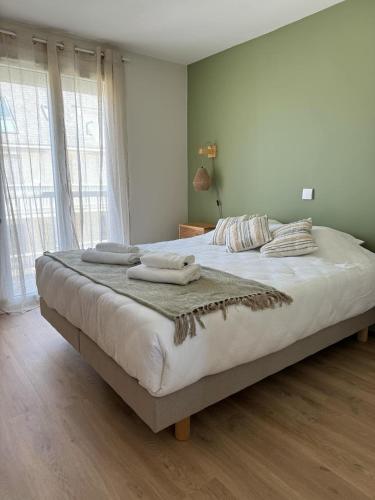 une chambre avec un grand lit avec des serviettes dessus dans l'établissement Appartement Vue mer 