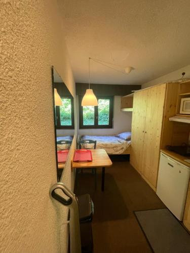 Cette petite chambre comprend une table et un lit. dans l'établissement studio 1 personne heidi 6, à Megève