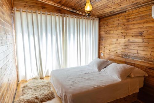 a bedroom with a bed in a wooden wall at Kazerma e Cerenit in Surrel
