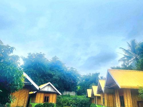 a group of houses with trees in the background at Nong Khiaw Ing Ing Mountain View in Nongkhiaw