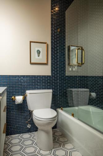 a bathroom with a toilet and a tub and a sink at Blackbird Hotel in New Orleans