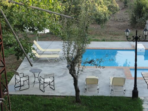 a group of chairs and a table next to a pool at Zeus House in Agios Konstantinos