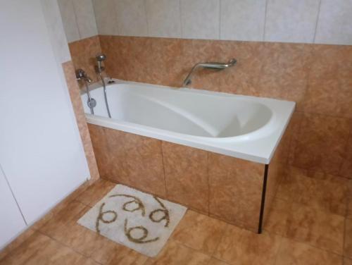 a white bath tub in a bathroom with a tile floor at R GARDEN Pointe Aux Sables in Pointe aux Sable