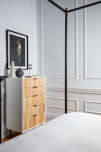 a bedroom with a bed and a wooden dresser at Blackbird Hotel in New Orleans