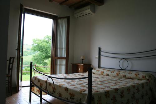PreselleにあるAgriturismo Serratoneのベッドルーム1室(ベッド1台、大きな窓付)