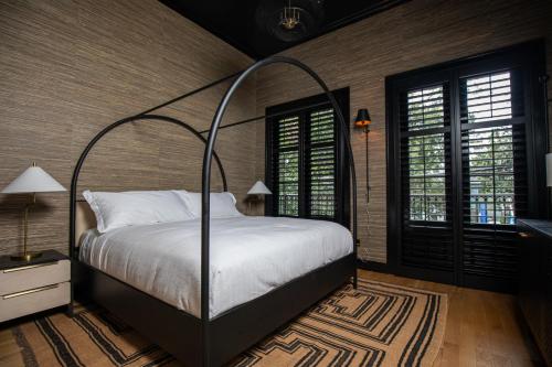 a bedroom with a bed with a metal canopy at Blackbird Hotel in New Orleans