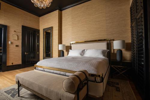 a bedroom with a large bed and a chandelier at Blackbird Hotel in New Orleans