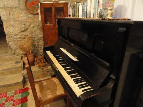 a black piano sitting in a room with books at Zeus House in Agios Konstantinos