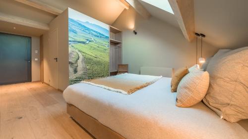 a bedroom with a bed with a large painting on the wall at Domaine Carrel & Senger in Jongieux