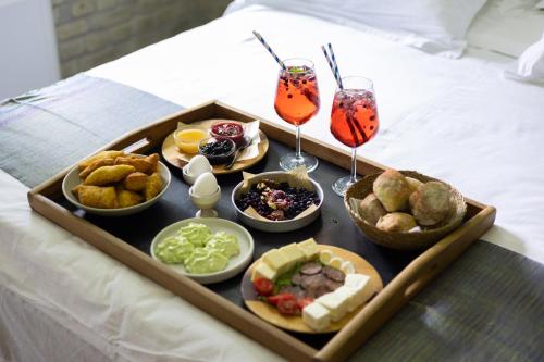 a tray of food on a bed with two drinks at Kazerma e Cerenit in Surrel