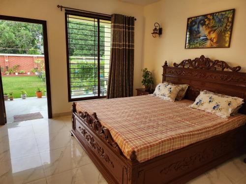 a bedroom with a large bed with a large window at Aquavilla vedic village in Sikarpur