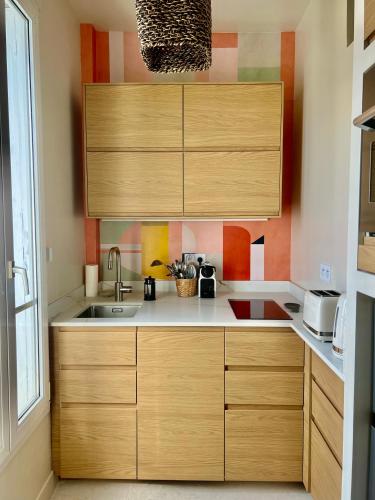 une cuisine avec des armoires en bois et un évier dans l'établissement Magnifique appartement entièrement rénové, à Boulogne-Billancourt