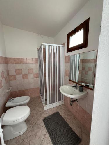 a bathroom with a toilet and a sink at Casa Vacanze Tra gli Olivi in Bonarcado
