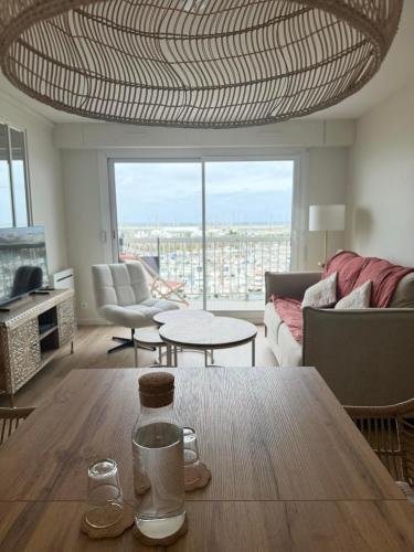 un salon avec une table et une grande fenêtre dans l'établissement Appartement Vue mer 