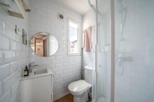 une salle de bain blanche avec des toilettes et un lavabo dans l'établissement Appartement confortable dans le centre de Paris, à Paris