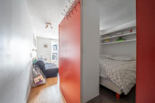 - une chambre avec une porte rouge à côté d'un lit dans l'établissement Appartement confortable dans le centre de Paris, à Paris