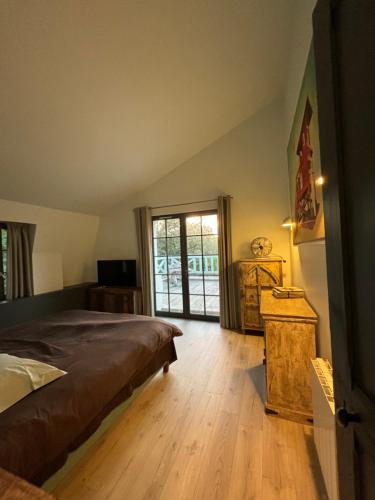 une chambre avec un lit et une porte coulissante en verre dans l'établissement Maison acces plage, à Trouville-sur-Mer