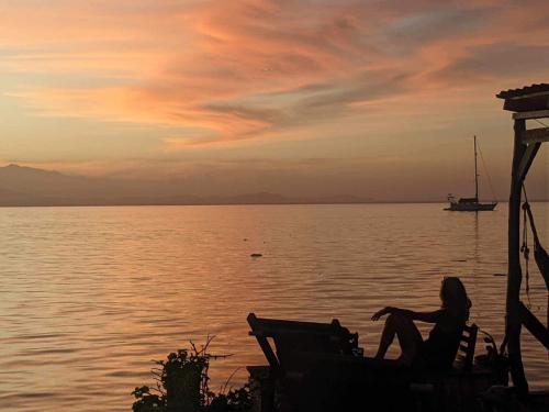 a woman sitting on a chair in front of the water at Life is Good in Bocas del Toro