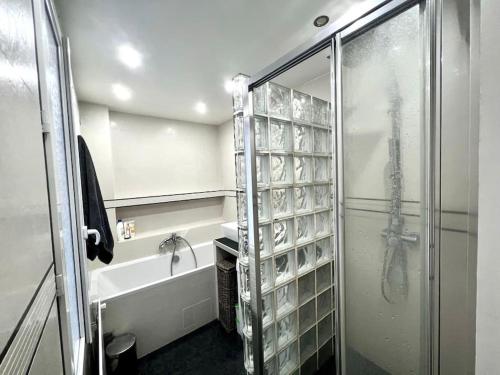 La salle de bains est pourvue d'une douche, d'un lavabo et d'une baignoire. dans l'établissement Champs-Elysées - Arc de Triomphe - 2 pièces - 4p, à Paris