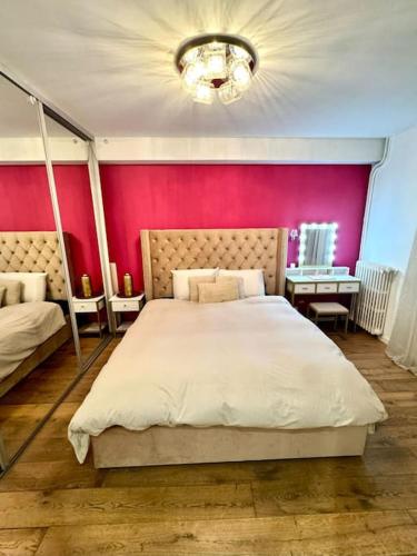 une chambre avec un grand lit avec un mur rouge dans l'établissement Champs-Elysées - Arc de Triomphe - 2 pièces - 4p, à Paris