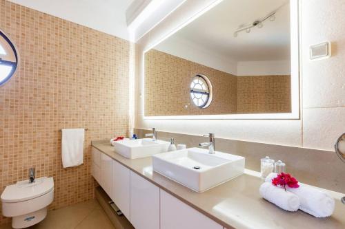 une salle de bain avec deux lavabos et un miroir dans l'établissement Casa Das Palmeiras, à Loulé
