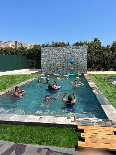 un groupe de personnes dans une piscine dans l'établissement grande villa avec piscine, à Bompas