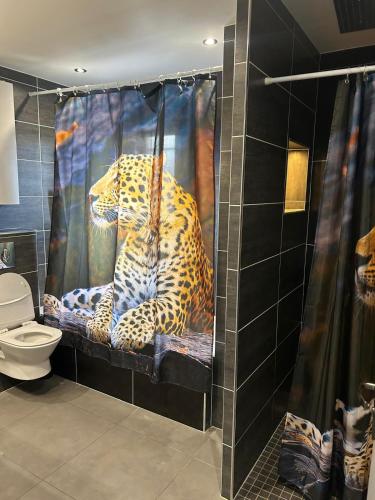 - un rideau de douche guépard dans la salle de bains pourvue de toilettes dans l'établissement grande villa avec piscine, à Bompas