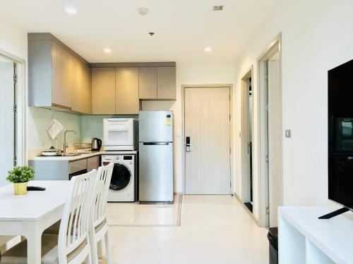 a kitchen with a refrigerator and a table at Two bedrooms and two bathrooms Thonglor in Bangkok