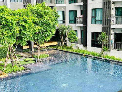 een zwembad voor een gebouw bij Rhythm sukhumvit 36 two bedrooms in Bangkok