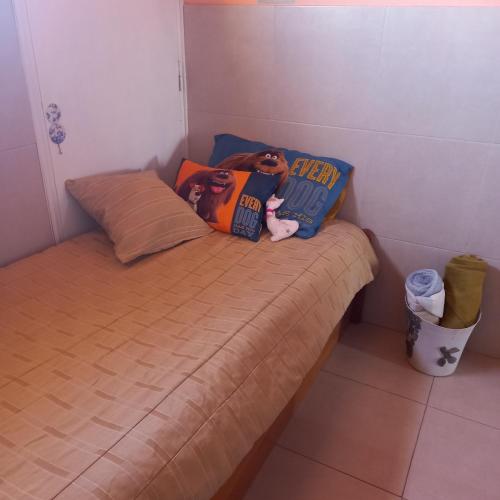 Una cama pequeña con una almohada y un perro encima. en Verdes montañas, en Villa Nueva