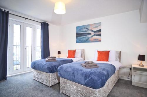 a bedroom with two beds with blue sheets at St Kats Mews 4 bed with parking in Peterborough