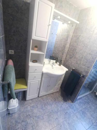 une salle de bain avec un lavabo blanc et un miroir dans l'établissement Appartement cosy avec extérieur à Bretenoux, à Bretenoux